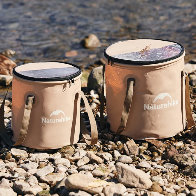 Collapsible camping buckets placed on rocky riverbank