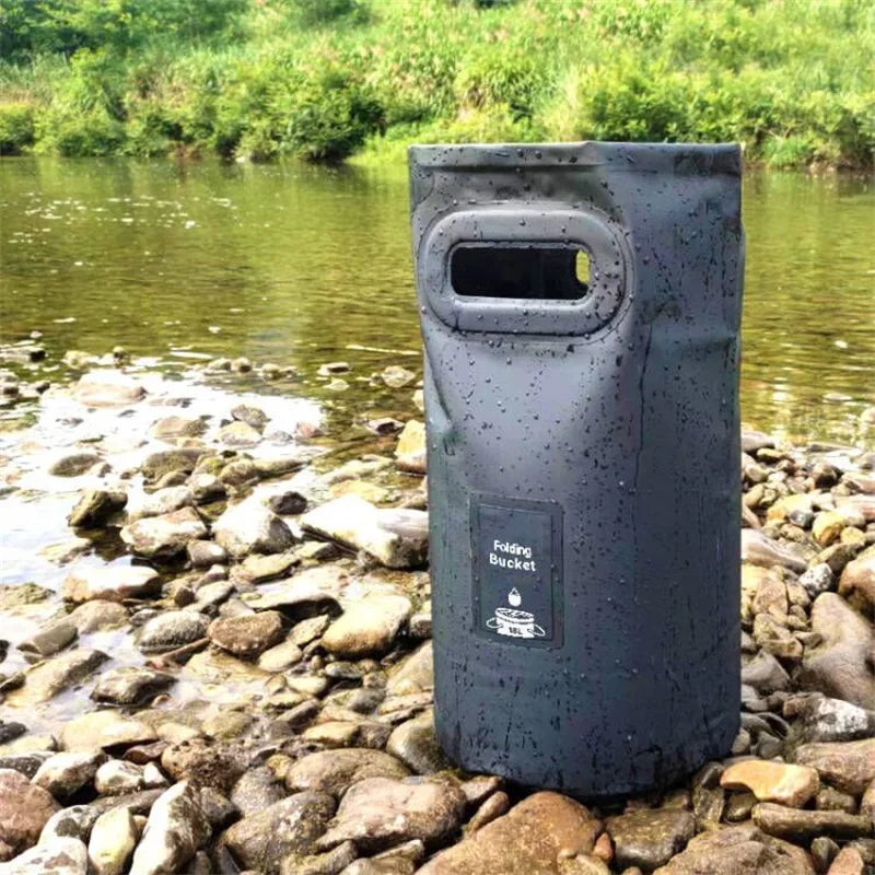 Collapsible fishing bucket standing on riverbank