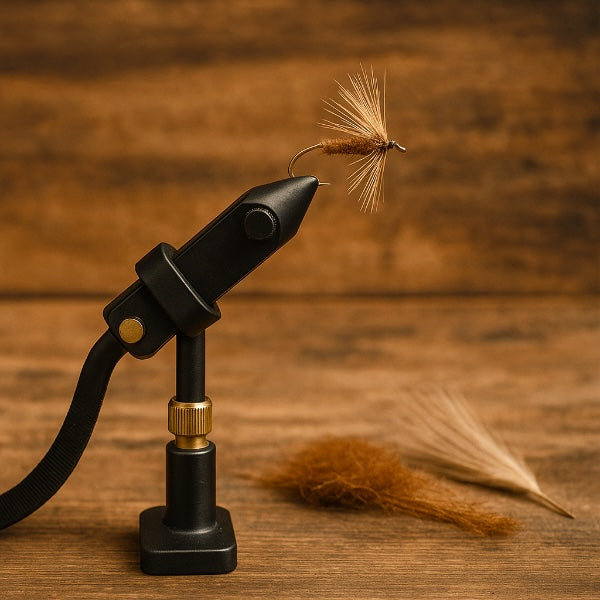 Black fly tying tool with a brown fly on a wooden background