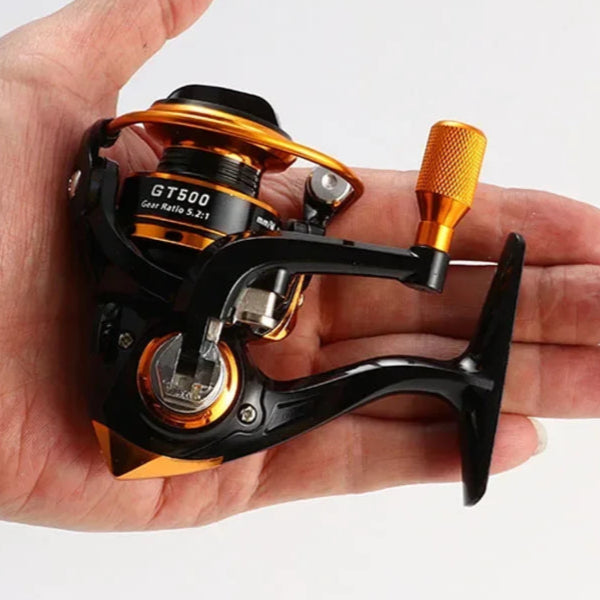 GT500 spinning reel shown in hand with lightweight body and orange metal spool design