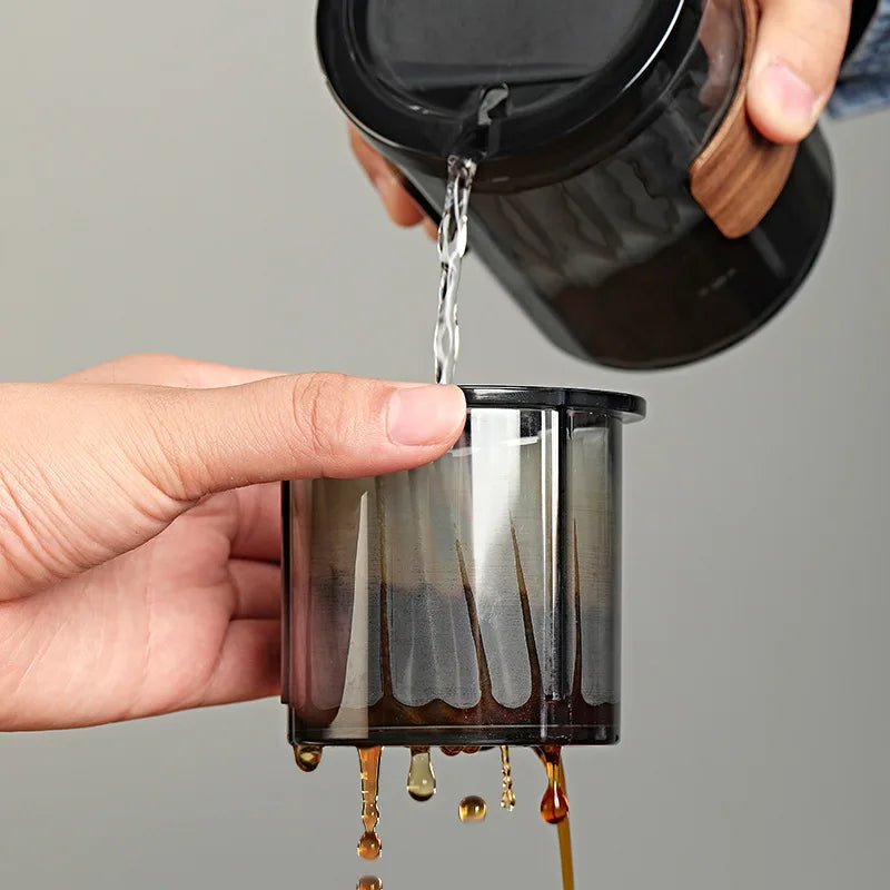 Hand pouring coffee through the portable filter into a cup, highlighting simple manual brewing for one or two people