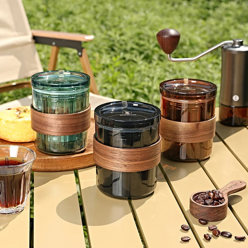 Complete five-piece portable coffee set arranged outdoors on a wooden table, ideal for camping or travel brewing