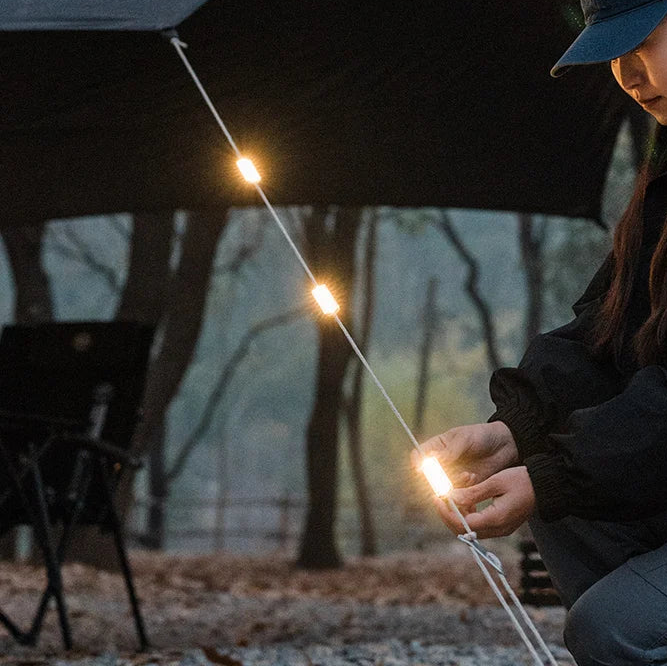 Tent rope warning light glowing at campsite