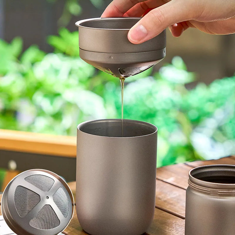 Hand pouring coffee through titanium filter into matching mug, showing smooth, paper-free brewing design