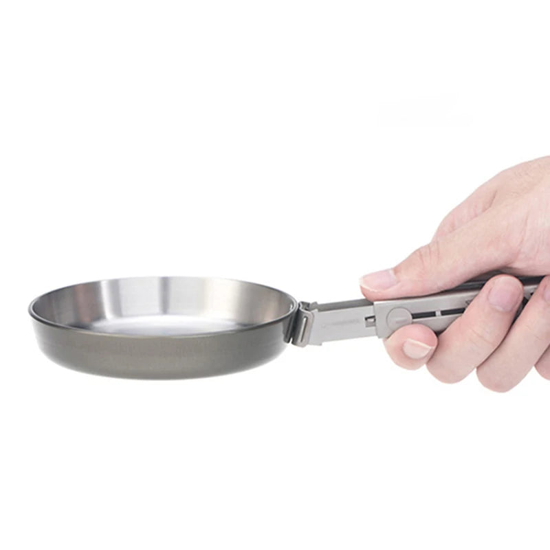 Hand holding shallow titanium camping frying pan