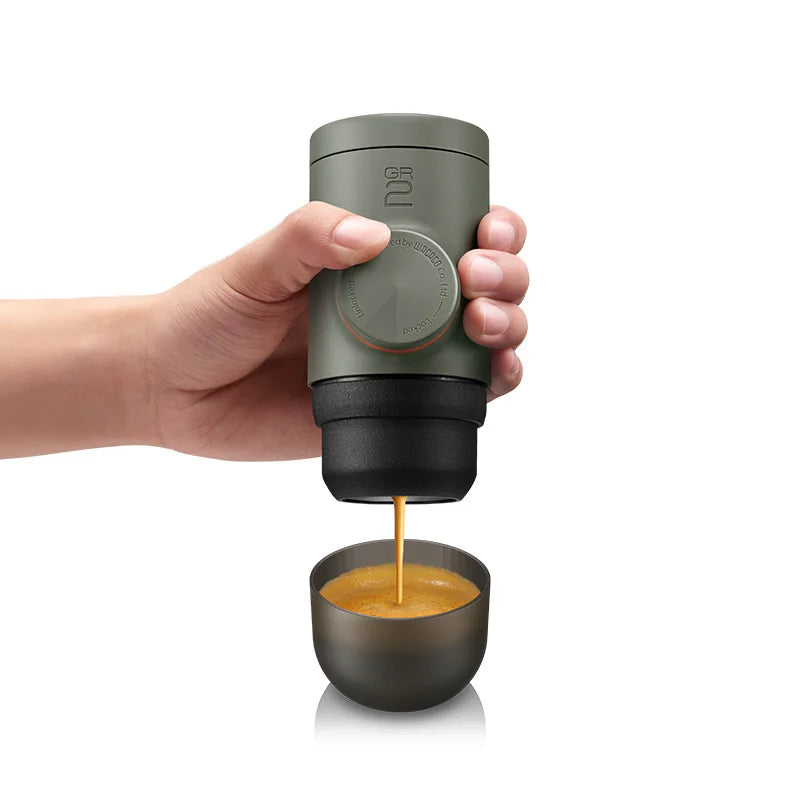 WACACO Minipresso GR2 handheld espresso maker brewing rich crema coffee into cup outdoors
