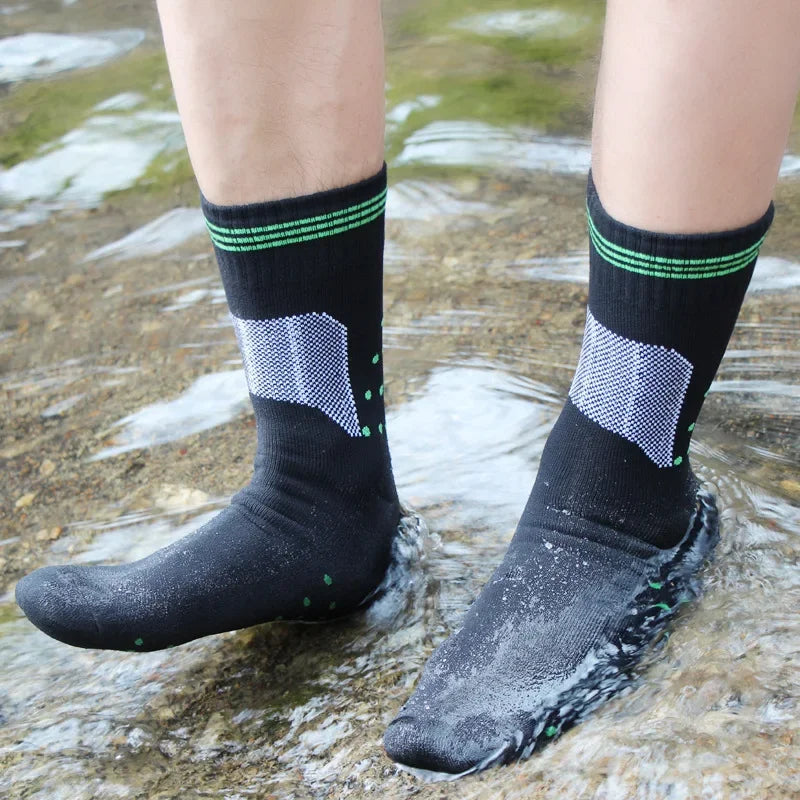 Black waterproof knee high hiking socks worn in stream
