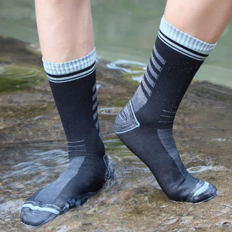 Grey waterproof knee high hiking socks standing in water