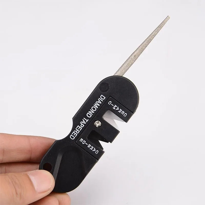 compact 4-in-1 pocket knife sharpener tool placed beside rocks outdoors