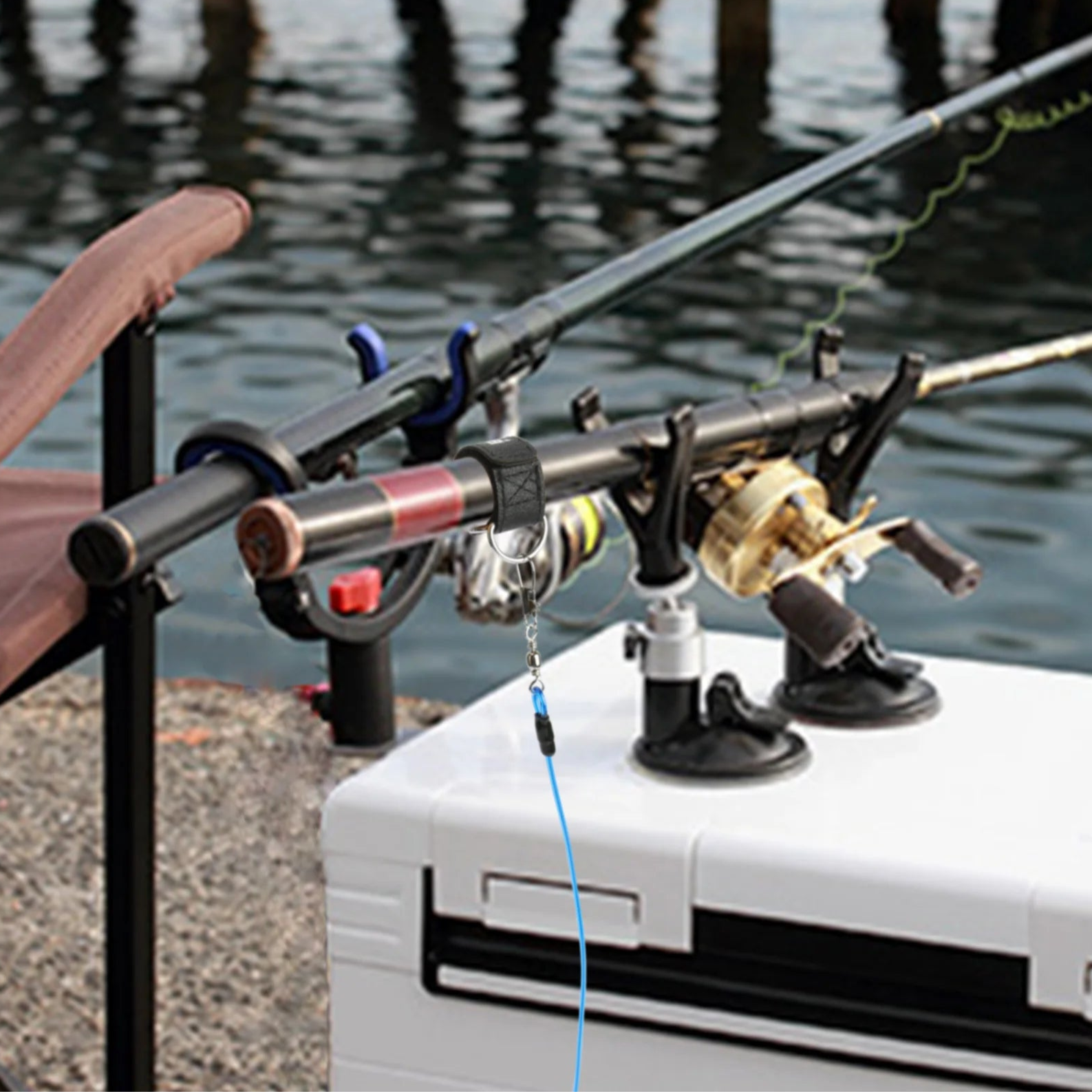 Angler using neoprene rod tie straps to bundle fishing rods beside a river