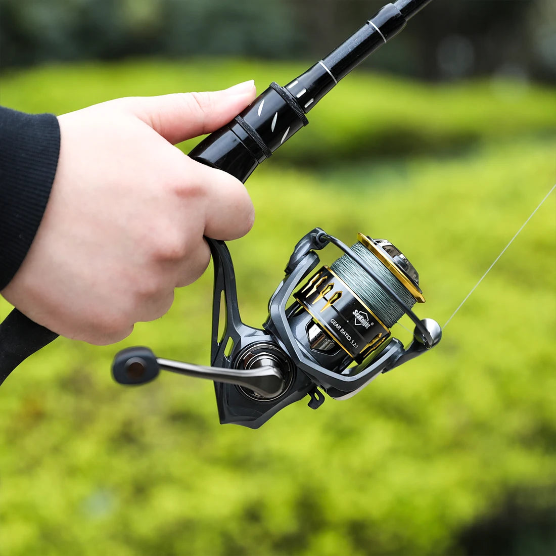 Angler holding ARCHER II baitcasting reel in use, showing ergonomic control and smooth action