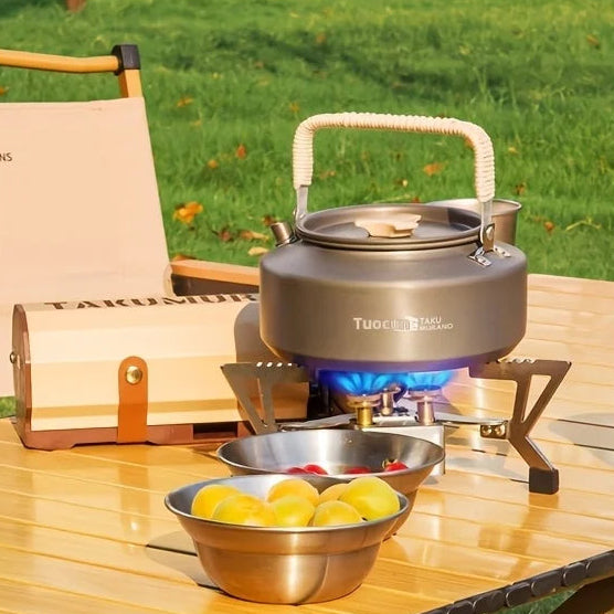 Compact cassette gas camping stove heating kettle and pot during outdoor picnic cooking setup