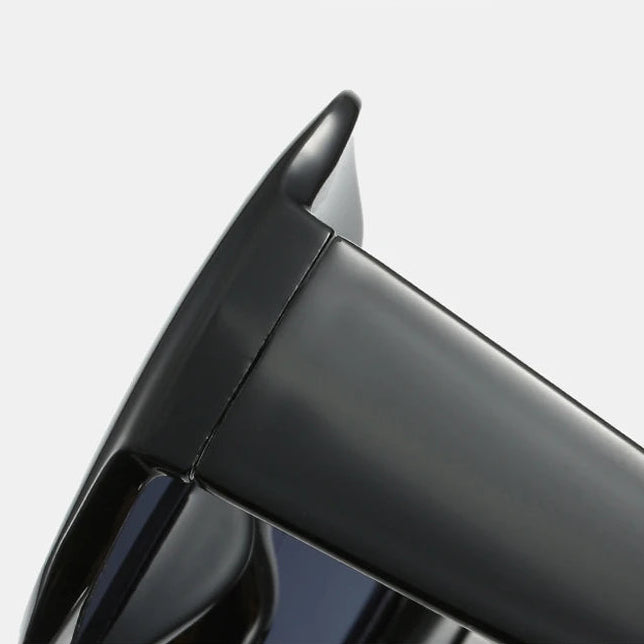 Close-up of DOHOHDO oversized square sunglasses arm and hinge detail showing durable plastic construction and gloss finish