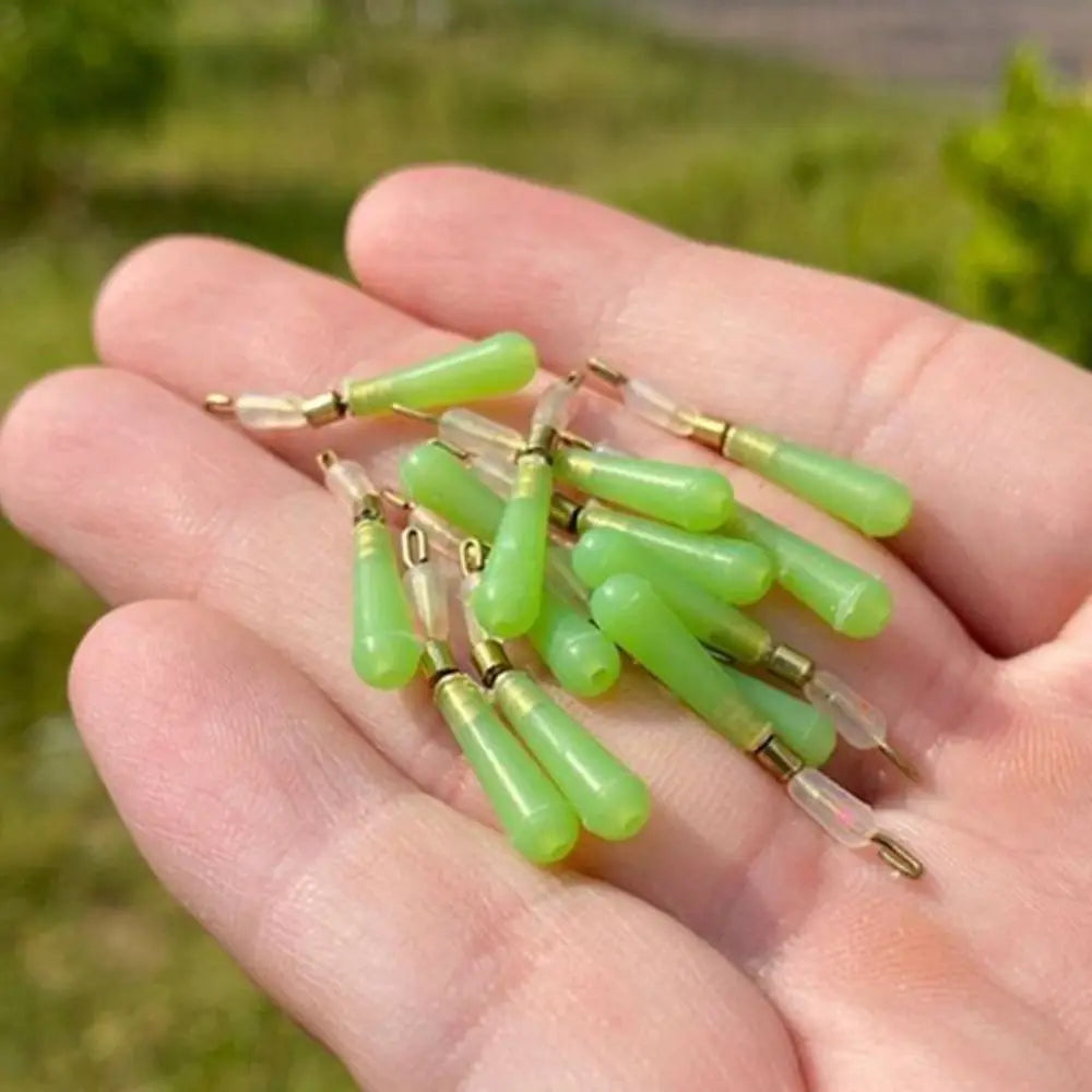 Hand holding multiple green copper head float seats for fishing tackle assembly