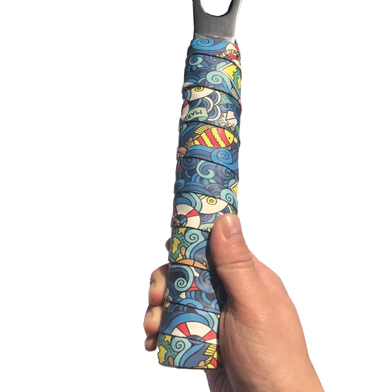 Hand holding rolled grip tape with printed design showing non-sticky textured surface