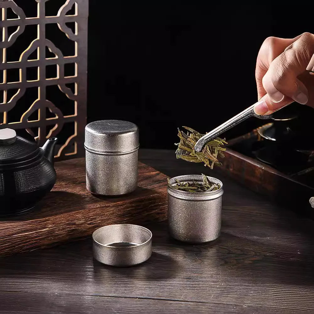 Hand opening titanium tea can filled with herbs, highlighting sealed and moisture-proof lid design