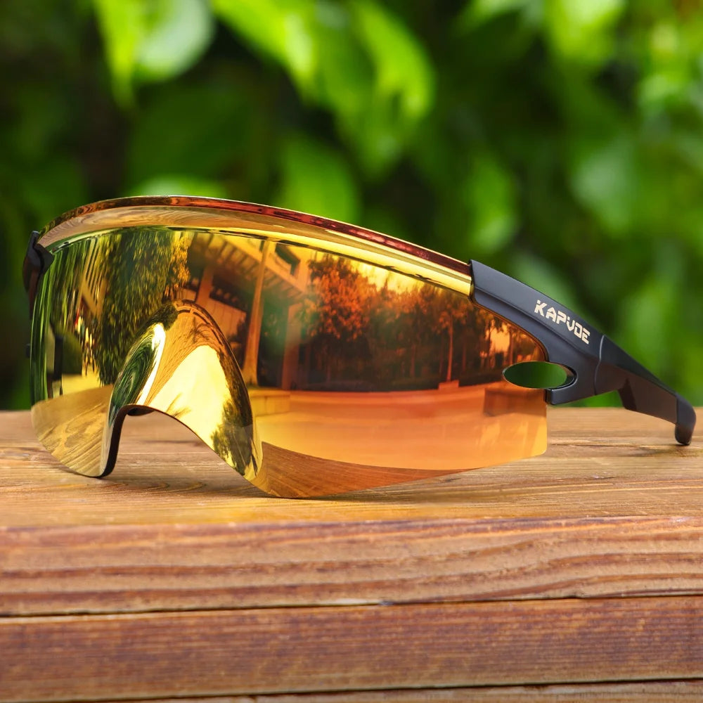 KAPVOE cycling sunglasses with orange photochromic lens displayed outdoors showing reflective coating and ergonomic design