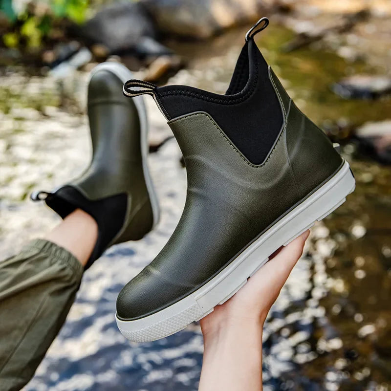 Grey men’s ankle gumboots held above shallow flowing water