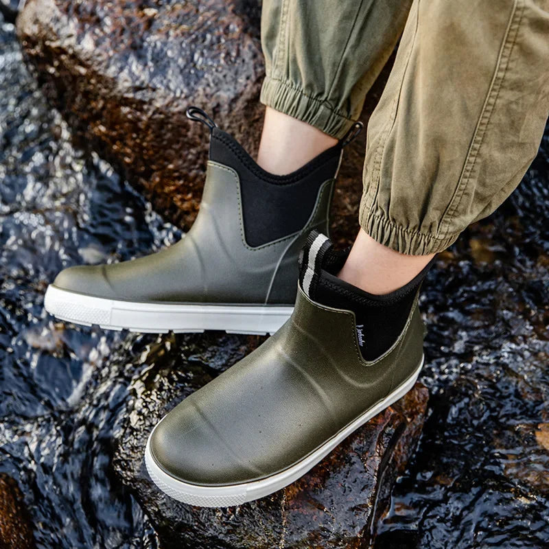 Grey men’s ankle gumboots worn while standing on wet ground