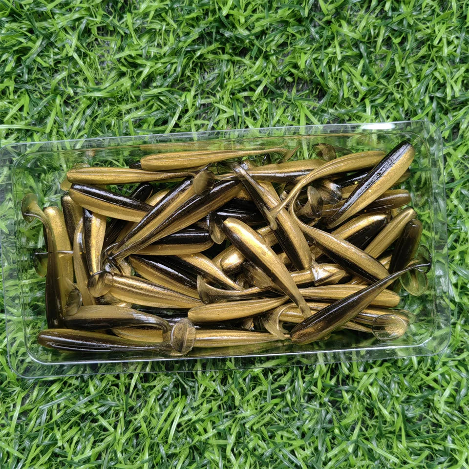 Brown micro soft worm lures laid out on grass background