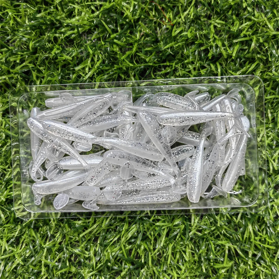 Clear micro soft worm lures laid out on grass background