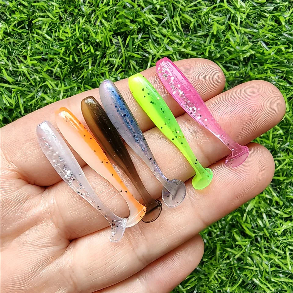 Hand holding micro soft worm lures in multiple colours