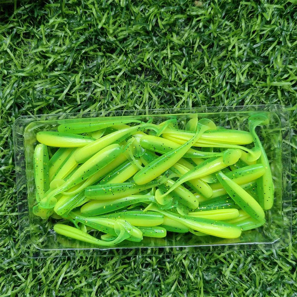 Green micro soft worm lures laid out on grass background
