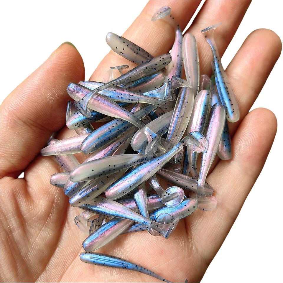 Hand holding multiple micro soft worm fishing lures