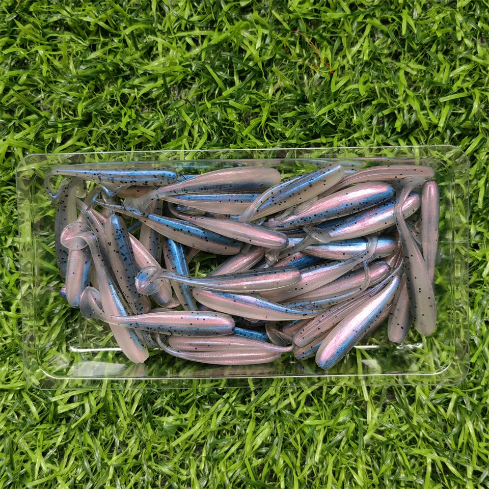 Multicolour micro soft worm lures laid out on grass background