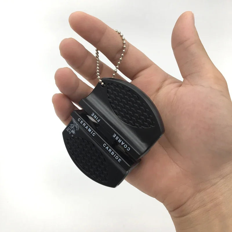 Small round fishing knife sharpener with textured grip shown in hand for size reference