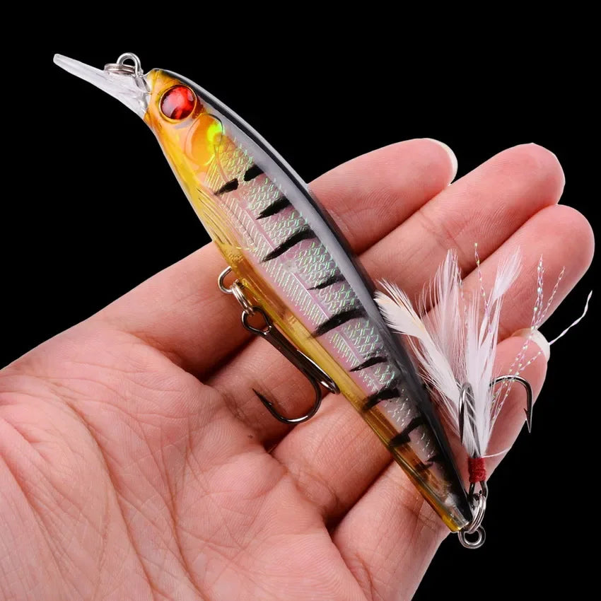 Minnow crankbait lure held in hand showing laser finish and treble hooks