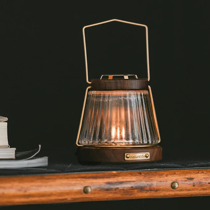 NATUREHIKE Huoxi candle lantern glowing warmly outdoors on wooden surface creating soft evening light