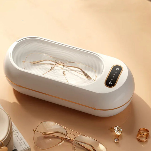 Compact 500ml portable ultrasonic cleaner used for cleaning glasses and jewellery on tabletop with soft lighting