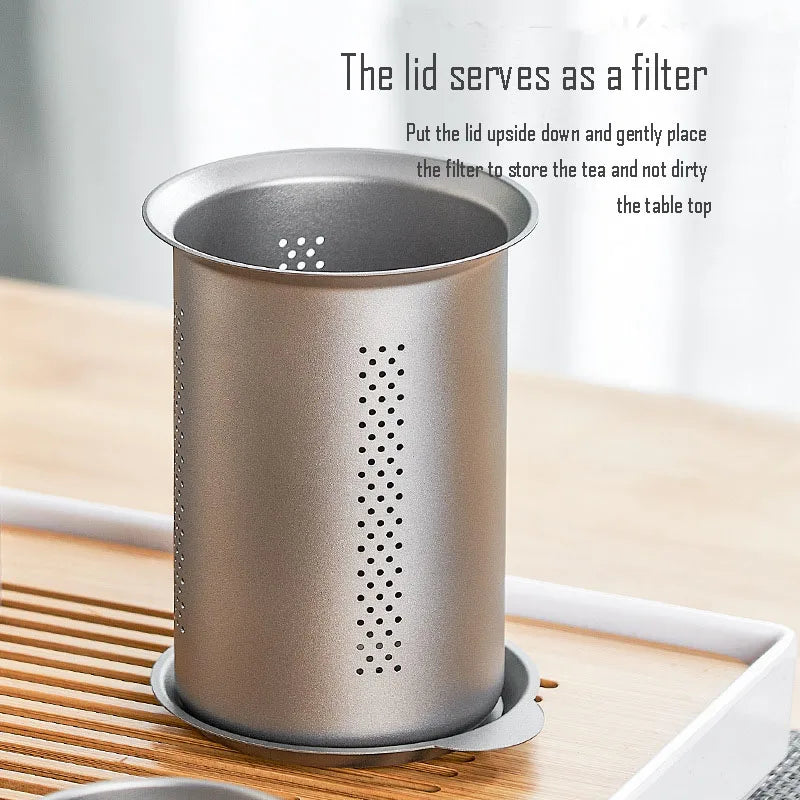 Person pouring tea from titanium infuser into matching cups demonstrating anti-scalding design and easy use
