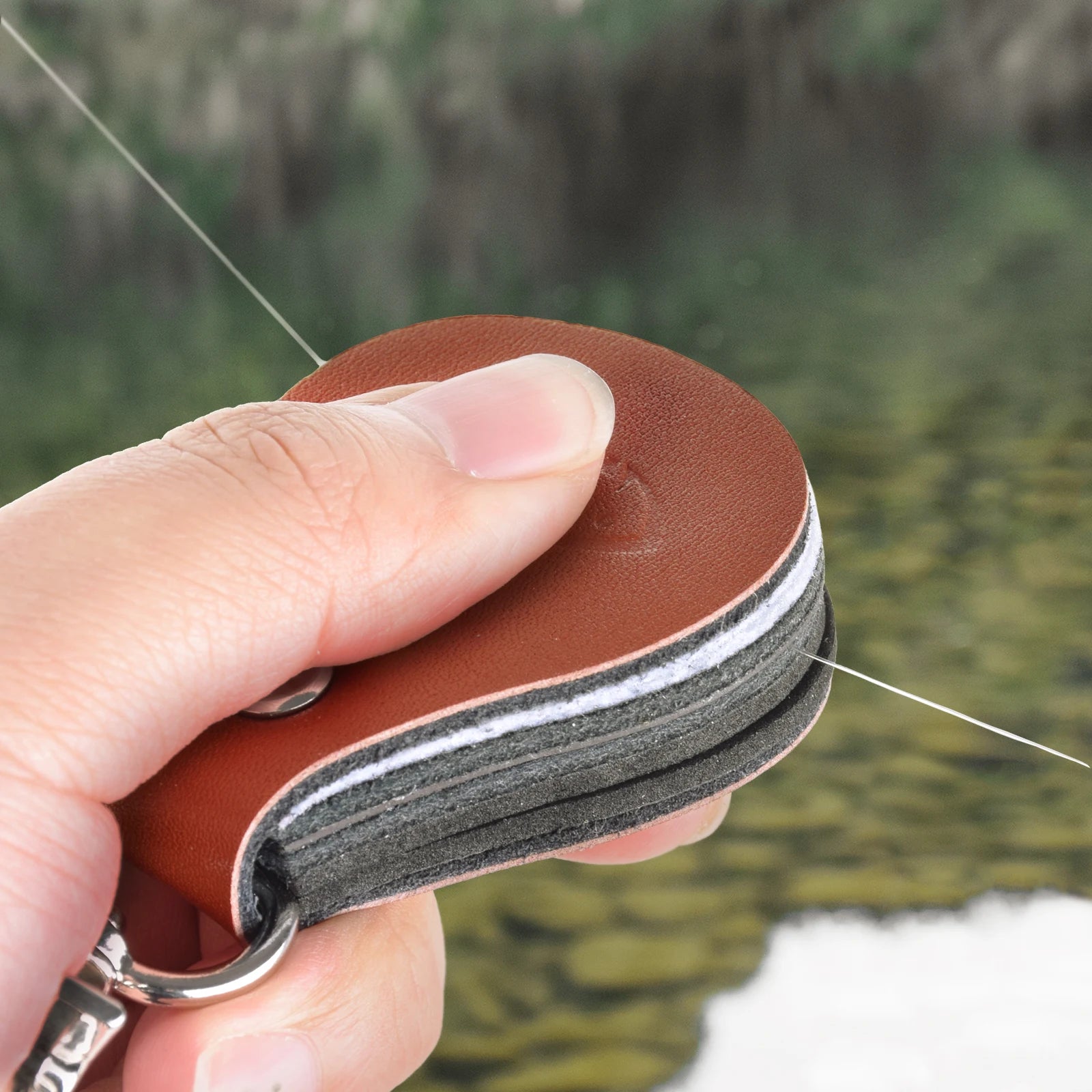 Angler using SF fly line straightener to smooth and clean fly leader for improved casting accuracy