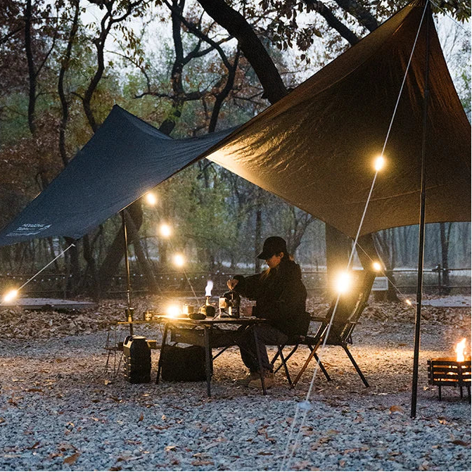 Tent rope warning light illuminating tarp shelter