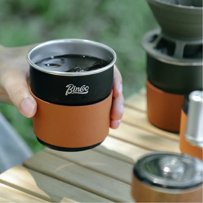 Hand holding titanium outdoor coffee cup with double-wall insulation and clean finish