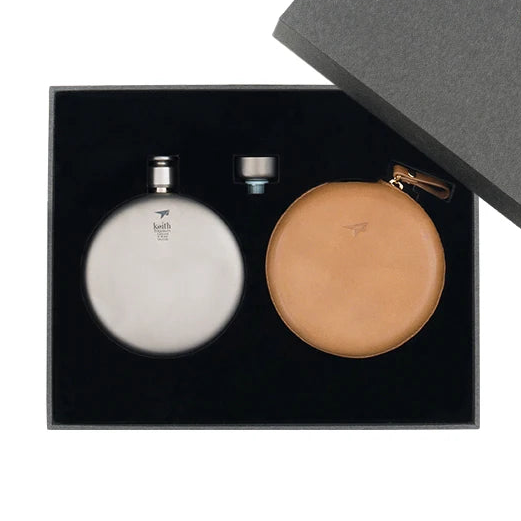 Titanium flask shown in box with silver flask and leather case