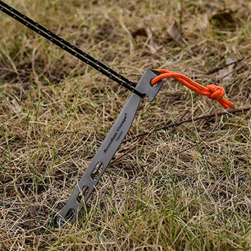 Titanium tent stake securing guy line in soil