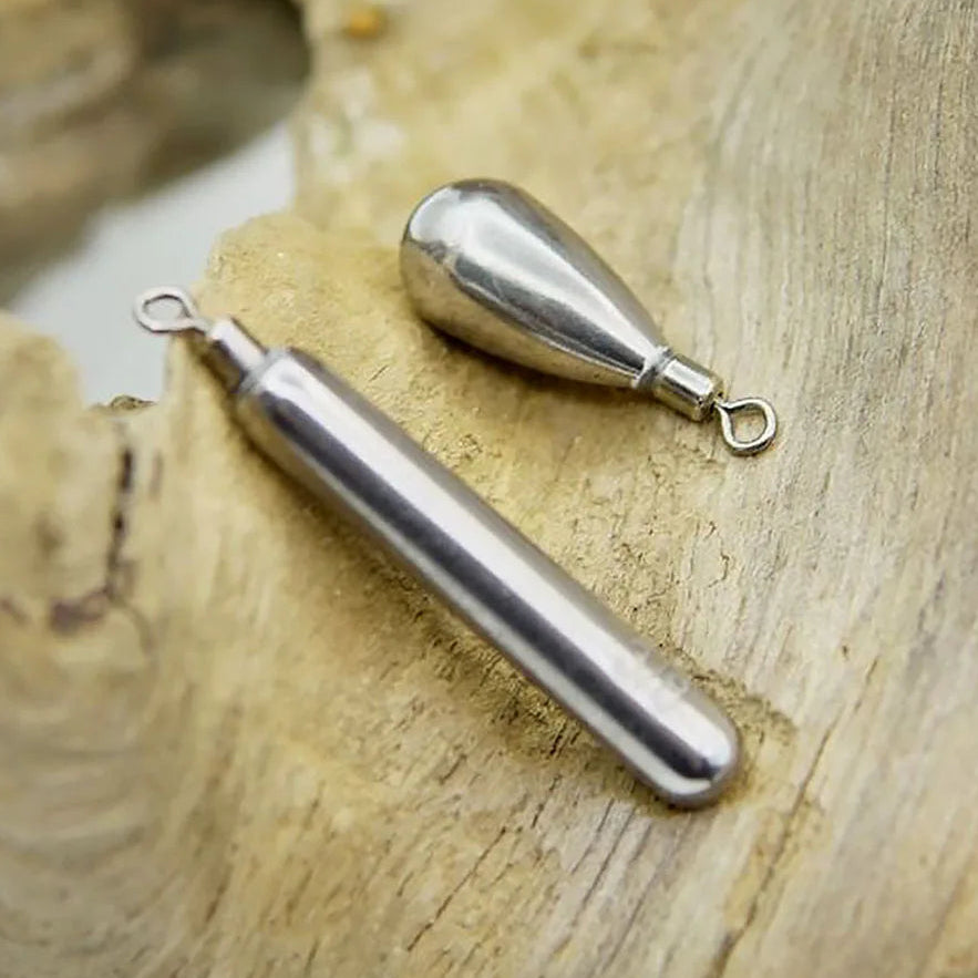 Two metal fishing lead weights on a wooden surface