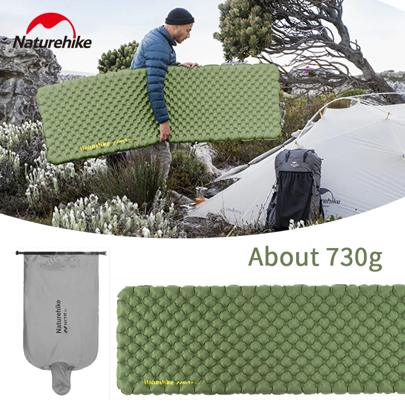 Person carrying green ultralight inflatable sleeping mat near tent