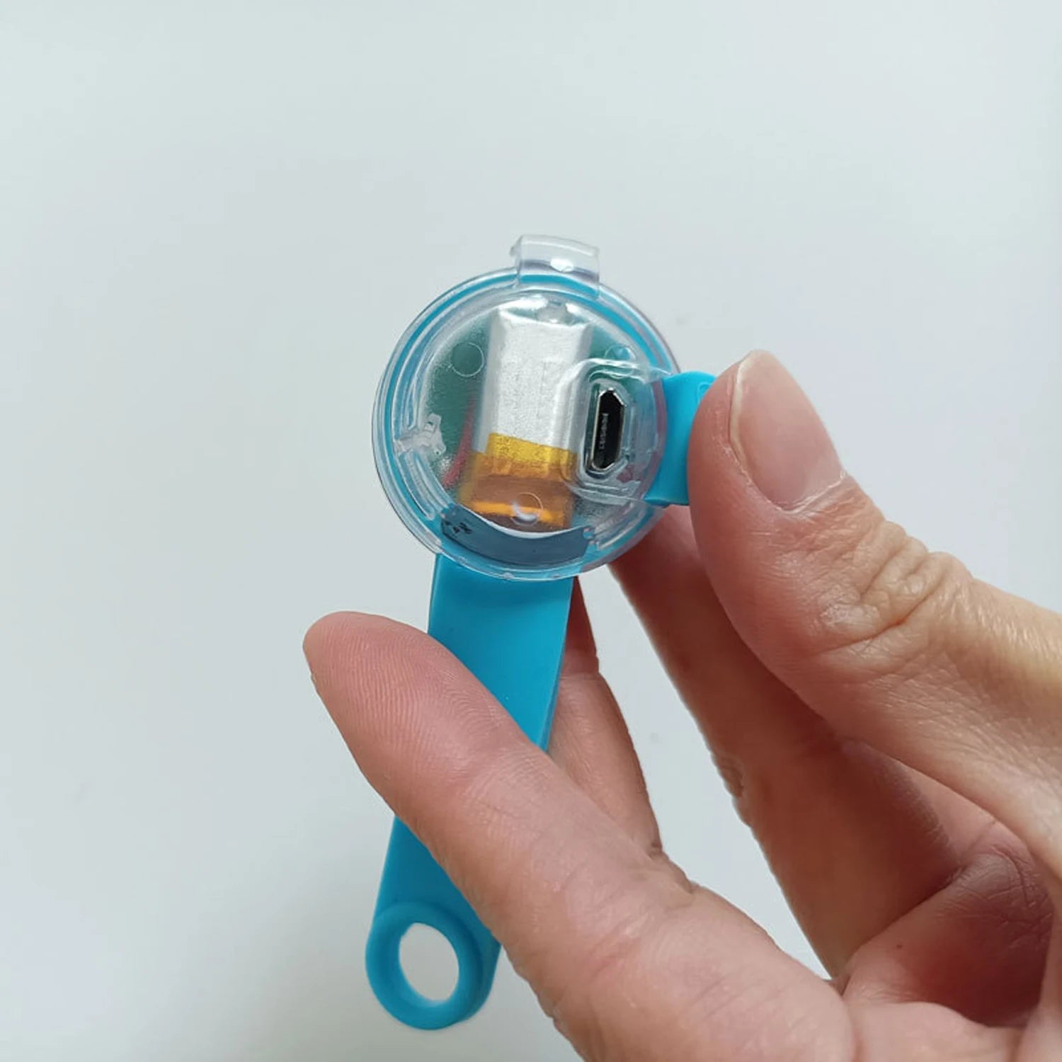 Hand holding blue USB rechargeable LED dog collar light