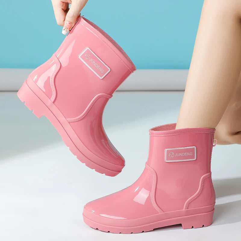 Pink women’s ankle gumboots lifted by heel showing ankle height