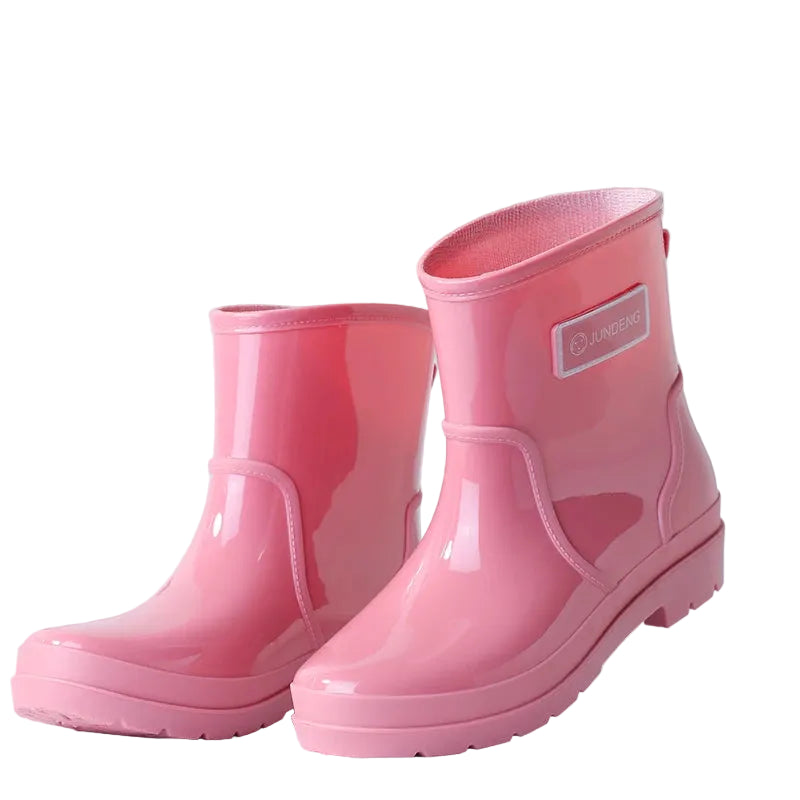 Pink women’s ankle gumboots pair standing upright on white background